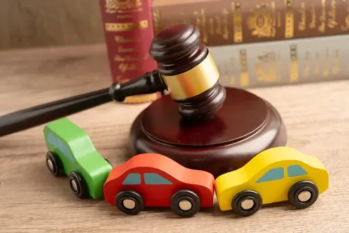 A gavel near toy cars to represent a car accident lawyer handling a case.