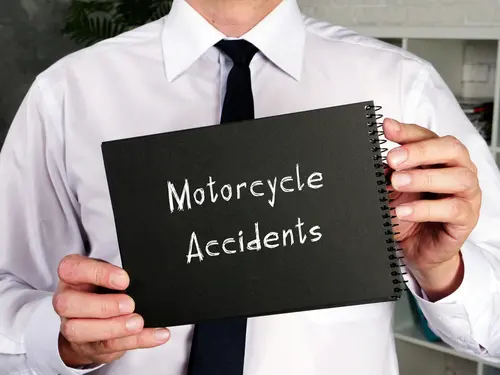 A motorcycle accident lawyer holding a notepad titled motorcycle accidents.