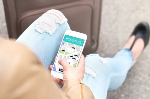 A woman looking at her rideshare app to represent a case where a rideshare accident lawyer would use as evidence.